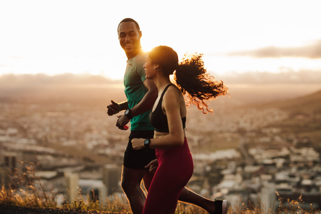 Man and woman on a run laughing together for a healthy body.