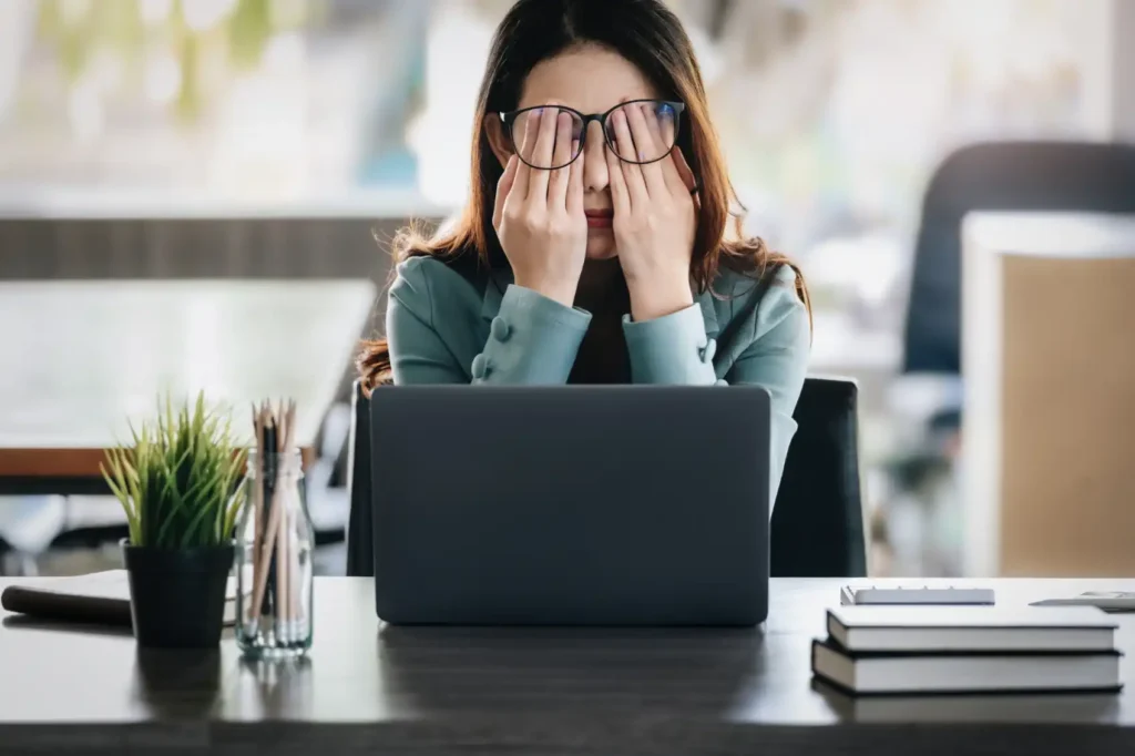 A stressed woman, overwhelmed by a heavy workload and uncertainty, represents mental health issues, highlighting how proper methylation, essential for neurotransmitter production, supports emotional stability and cognitive function.